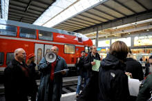 Wie die am Gleis 11 ankommenden 'Gastarbeitter' wurden auch die Theaterbesucher am Bahnsteig begrüßt und per Megaphon zur Weiterleitungsstelle im Bunker gelotst. Im Bild zu sehen (1. und 2. von links) sind der Dolmetscher Remzy Özbay und der Arbeitsvermittler Kurt Spennesberger (Foto: Andrea Huber, München).