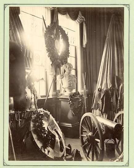 Saal IV des Bayerischen Armeemuseums war den „Helden und Vorbildern“ gewidmet, also großen Persönlichkeiten der bayerischen Militärgeschichte. Auf der um 1890 entstandenen Fotografie sieht man die Büste des Generals v. Hartmann umgeben von französischen Beutestücken. Hartmann, der seine Soldatenlaufbahn in der Armee Napoleons begonnen hatte, führte 1870/71 das II. Bayerische Armee-Corps gegen Frankreich. Für die Wanderausstellung wurde seine Büste aus dem Museumsdepot geholt. © Bayerisches Armeemuseum, Ingolstadt