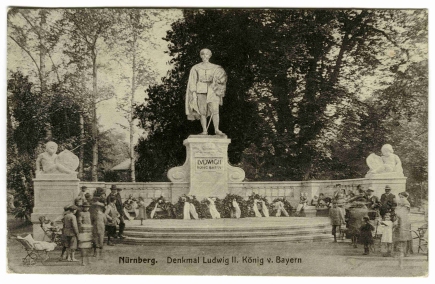 Vor fast genau hundert Jahren wurde das Ludwig-Denkmal im Nürnberger Stadtpark errichtet. Die Postkarte zeigt das Monument kurz nach der feierlichen Enthüllung am 24. August 1913. Zu Füßen der Statue sind noch die anlässlich der Einweihungsfeier niedergelegten Kränze zu sehen. Die rund vier Meter hohe Bronzefigur des Königs im Ornat des Hubertusritterordens steht auf einem Sockel, flankiert von zwei Putten, die Schilde mit den Wappen Bayerns und Nürnbergs präsentieren. Um Metall für die Herstellung von Munition zu gewinnen, wurde die Statue 1944 eingeschmolzen. Die verbleibenden Teile wurden nach dem Zweiten Weltkrieg abgetragen. © Haus der Bayerischen Geschichte, Augsburg