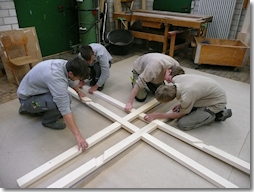 Schüler der Georg-Schäfer-Berufsschule in Schweinfurt setzen das erste Sprossenkreuz des Tretradkrans zusammen, den die Besucher während der Landesausstellung selbst bedienen können. (Foto: © Georg-Schäfer-Berufsschule)
